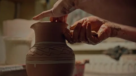 Close up potter's hands attaches hadle to clay jug and strengthens its form Stock Footage 257800276