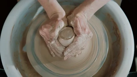 Close-up of potter's hands covered with clay making beautiful pot on throwing Stock Footage 151716280