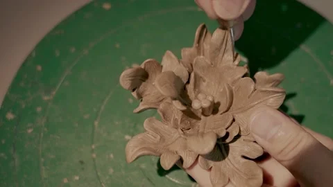 Close-up of potter's hands covered with clay making beautiful flower on throwing Stock Footage 152397377