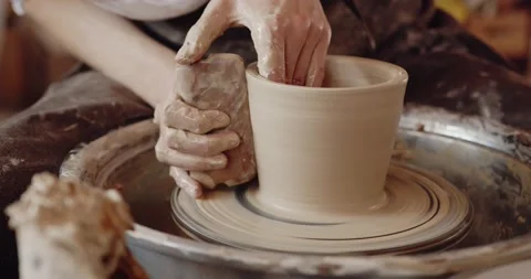 Close-up of potter's hands covered with clay making beautiful vase on throwing Stock Footage 208076136