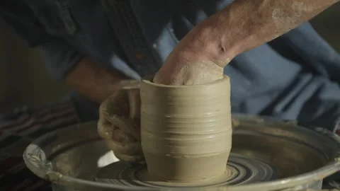 Close-up of a potter's hands working with clay on a potter's wheel in a workshop Stock Footage 248914796