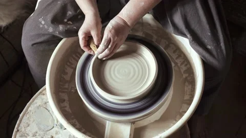 Close-up of potter's hands working with wet clay on a pottery wheel Stock Footage 132040077