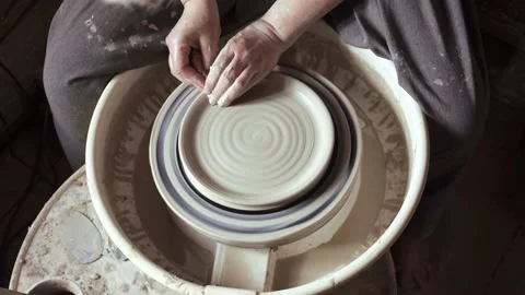 Close-up of potter's hands working with wet clay on a pottery wheel Stock Footage 132041329