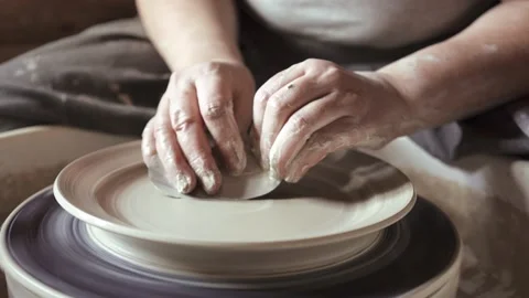 Close-up of potter's hands working with wet clay on a pottery wheel Stock Footage 132041826