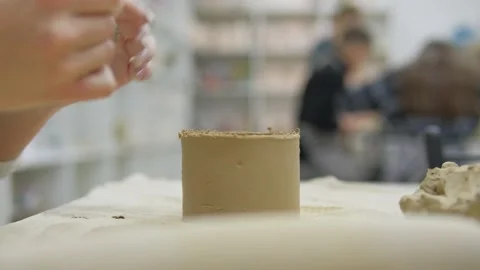 A close-up of a pottery masterclass where a participant skillfully shapes a clay Stock Footage 302547371
