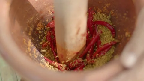 Close up pounding chilli in stone mortar.Top view hands of woman. Stock Footage 240943901