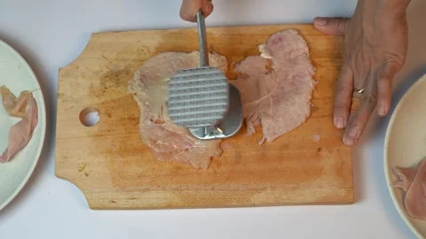 Close Up of Pounding Raw Chicken Fillet Using Meat Tenderizer Tool Stock Footage 334324018
