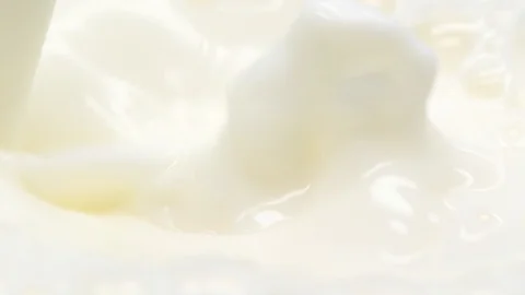 Close-up of pouring and splashing milk, slow motion Stock Footage