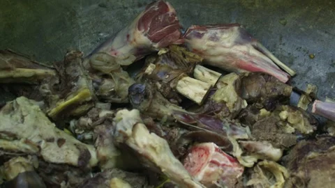 Close up pouring broth into cauldron for pilaf with meat, yellow carrots and oil Stock Footage 332643641