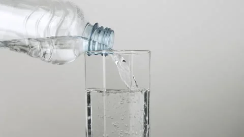 Close up pouring fresh clean drinking water into glass from plastic bottle Stock Footage 263870187