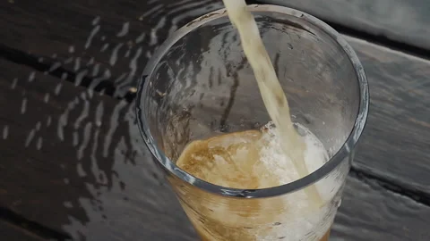 Close Up Pouring Fresh Cold Craft Beer into Glass on Dark Wood Table Vídeo Stock 335787905
