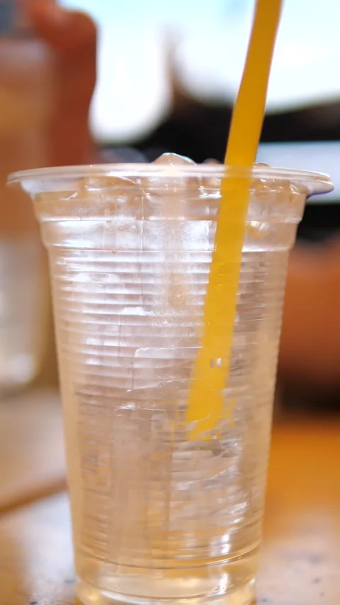 Close-up of pouring fresh drinking water from a bottle into a clear plastic cup Stockbeeldmateriaal 333853156