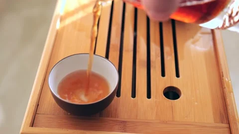 Close up pouring fresh hot tea from fairness pitcher glasses pot to bowl Stock Footage 218447763