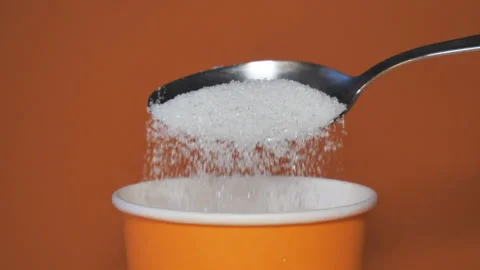 Close-up of pouring a full spoonful of white sugar crystals in slow motion Stock Footage 172206248