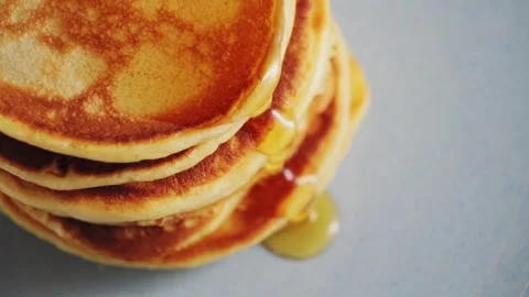 Close up pouring honey over stack of pancakes. Concept of sweet brunch. Stock Footage 321411081