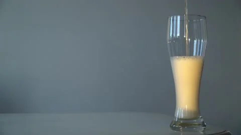 Close-up pouring light foamy beer in glass at white background. Stock Footage 199018214