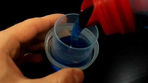 Close up pouring liquid laundry detergent into cap. Stock Footage 86414157