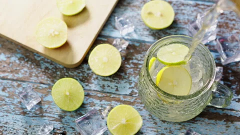 Close up pouring soft drinks, lemon tea soda. Lemonade with ice into glass Stock Footage 299888638