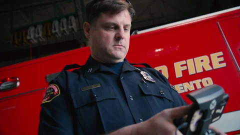 Close up POV of Fire chief checking pre-flight Aerial Drone functions. Stockbeeldmateriaal 203550972