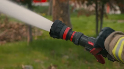 Close Up POV of Firefighters' hand with fire hose shooting out water. Stock Footage 201962862