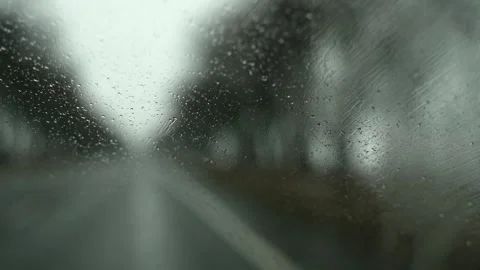 Close-up POV from inside a car onto raindrops on the windshield Stock Footage 263567003