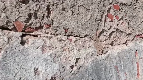 Close-up POV tracking shot moving along an ancient weathered stone wall. De.. Video stock 333100882