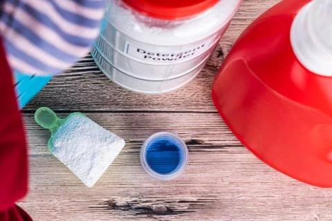 Close-up on powder and regular liquid laundry detergent on wooden surface Stock Photos