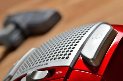 Close-up of power button of vacuum cleaner on floating floor and noozle in Stock Photos