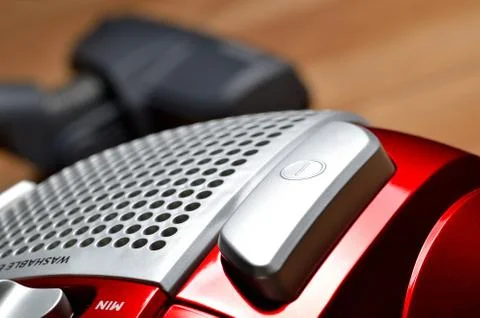 Close-up of power button of vacuum cleaner on floating floor and noozle in Stock Photos