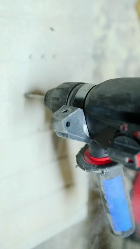 Close-up power drill creating hole in concrete wall with heavy construction dust Stock Footage 334861986