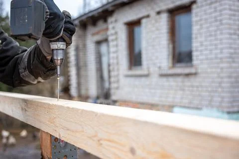 Close Up of Power Drill in Use with Brick Building in Background Stock Photos