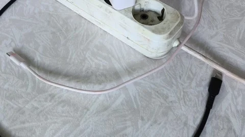 Close up of power strip with multiple plugs and tangled cables on wooden desk 库存影片 317668190