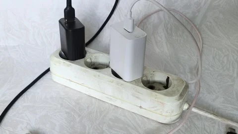 Close up of power strip with multiple plugs and tangled cables on wooden desk Stock Footage 317668207