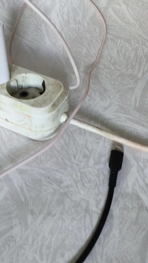 Close up of power strip with multiple plugs and tangled cables on wooden desk Stock Footage 317668246