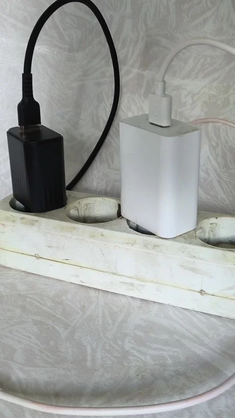 Close up of power strip with multiple plugs and tangled cables on wooden desk Stock Footage 317668248