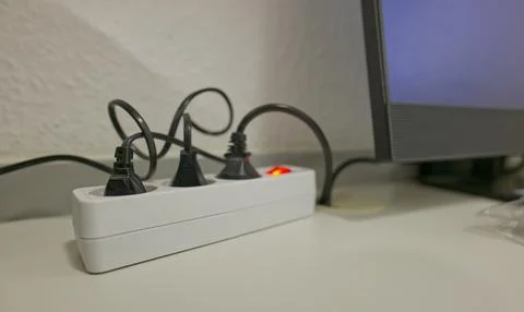 Close-up of Power Strip with Multiple Plugs and Monitor Stock Photos