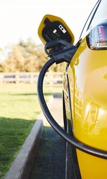 Close up of power supply plugged into an electric car being charged Stock Photos