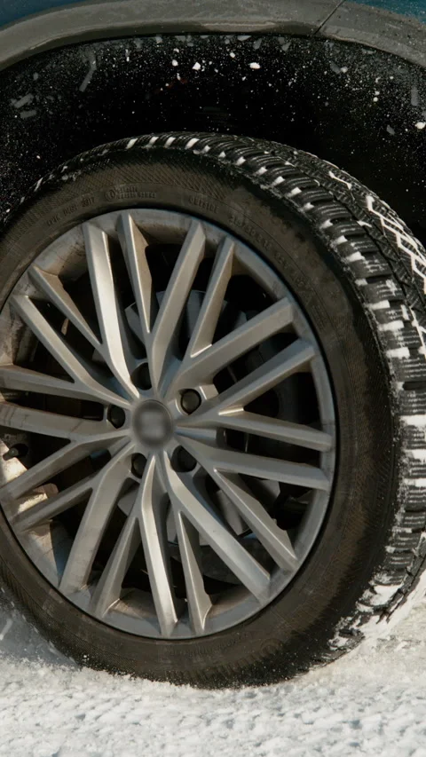 CLOSE UP: Powerful SUV's wheels spin in place and spew up pieces of white snow. Stock Footage 315800904