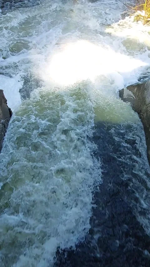 Close-up of powerful water flow at a dam spillway. Vertical video. Stock Footage 330452346