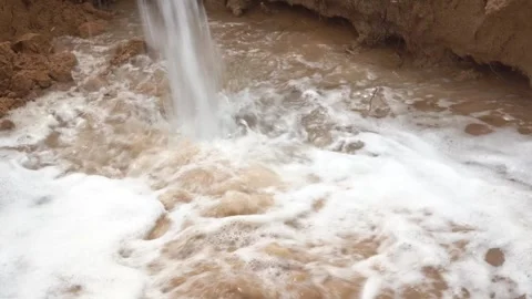 Close-Up of Powerful Water Stream Plunging into Muddy Basin with Engine Audio Vídeos de archivo 334605798