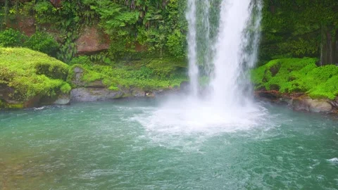 Close up of powerful waterfall stream splashing into emerald green water basin 動画素材 341806311