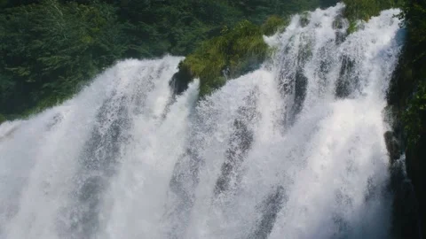 Close up of a powerful waterfall with water flowing off a cliff in nature. Stock Footage 157614565