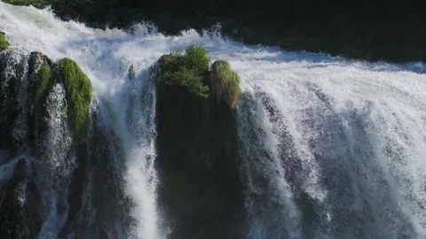 Close up of a powerful waterfall with water flowing off a cliff in nature. Stock Footage 157755585