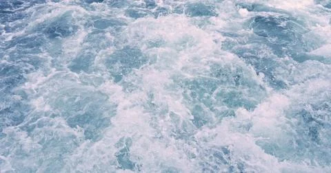 Close up powerful waves pulled out from boat. Water foam trace behind ship. Foto stock