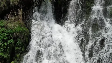 Close-up of powerful whitewater cascade falling over dark wet rocks Stock Footage 342843196
