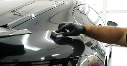 Close up to PPF installation process on a front headlight and hood. Stock Footage 112084665
