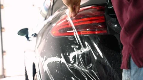 Close up to PPF installation process on a front (rear) headlight and bamper. Foto stock