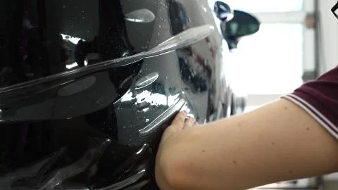 Close up to PPF installation process on a front (rear) headlight and bamper. Stock Photos