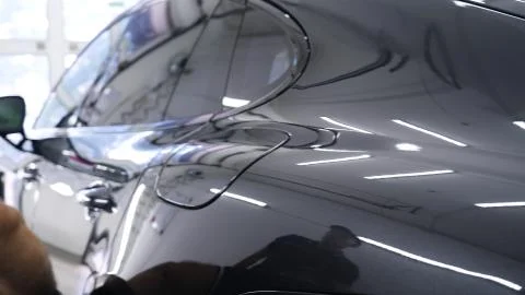 Close up to PPF installation process on a front headlight and hood. Stock Photos