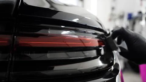 Close up to PPF installation process on a front headlight and hood. Stock-Fotos